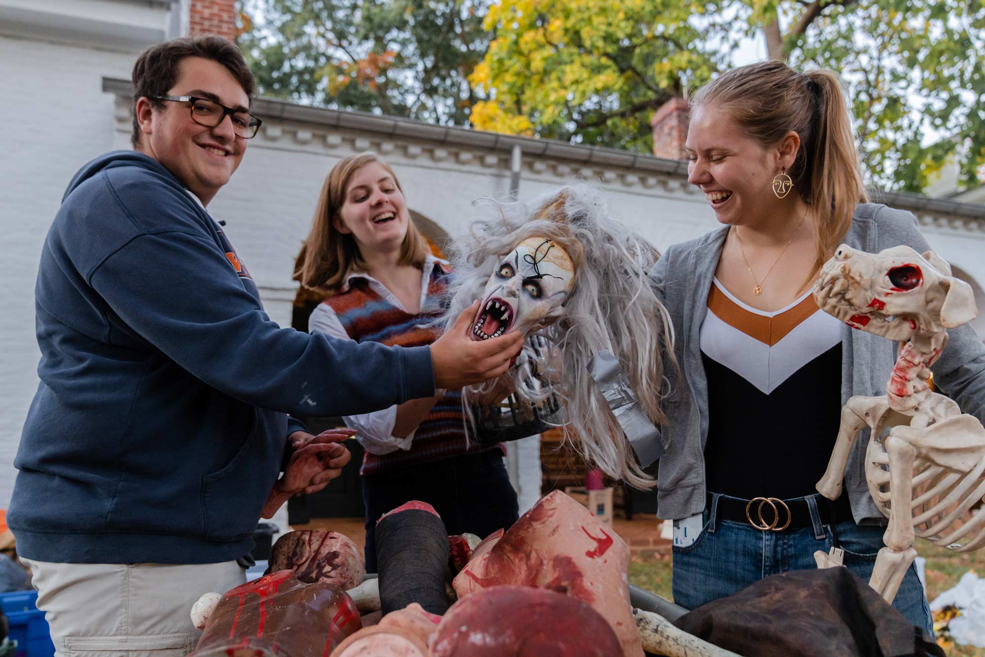 three students playing with halloween props