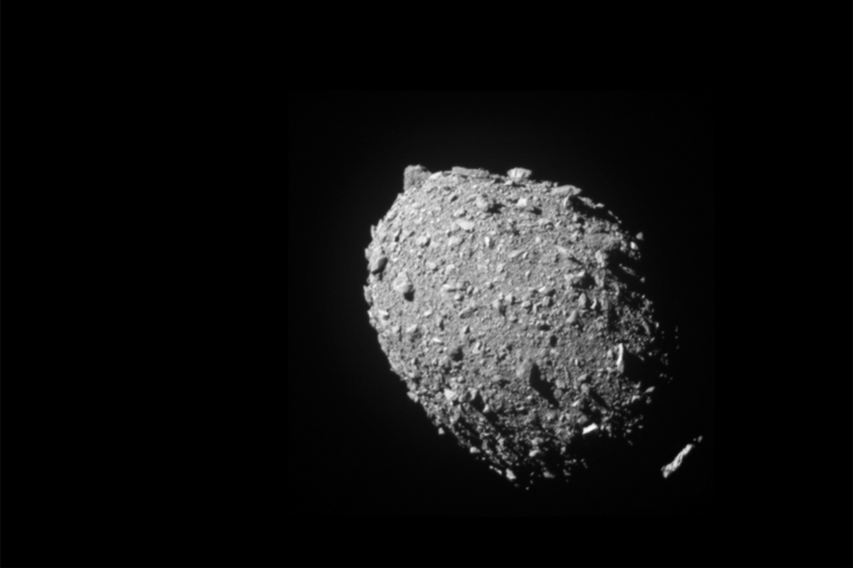 A rocky, egg shaped asteroid floating in the blackness of space
