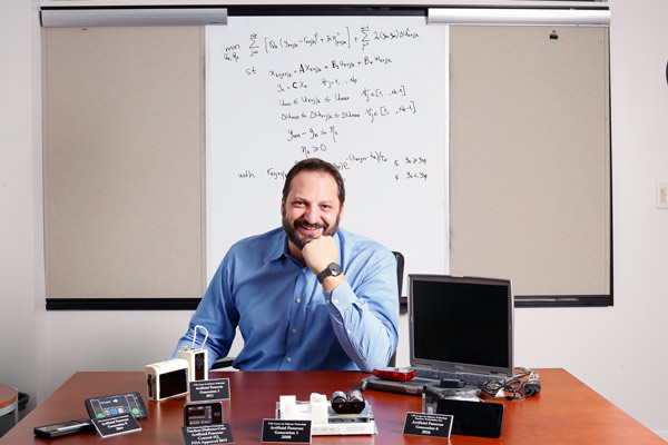 Portrait of Marc Brenton sitting at a desk in a white office