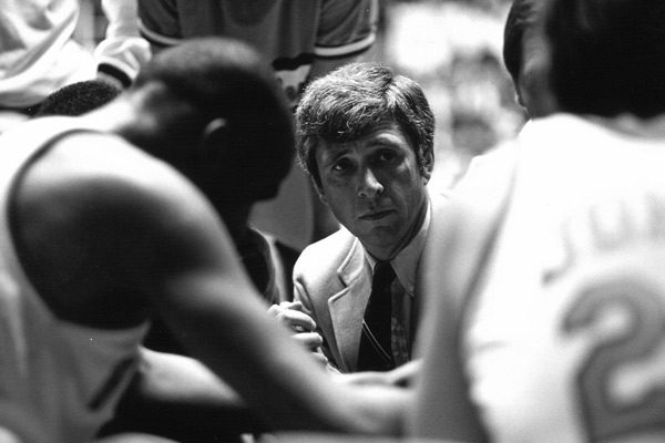Black and white photo of Terry Holland in a huddle during a game