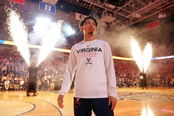 Kihei Clark on the court with pyrotechnics going off in the background