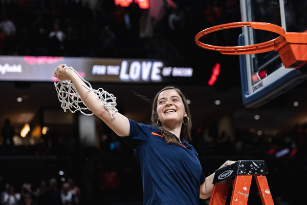 Anna Williamson on a ladder holding up the net after cutting it from the basket