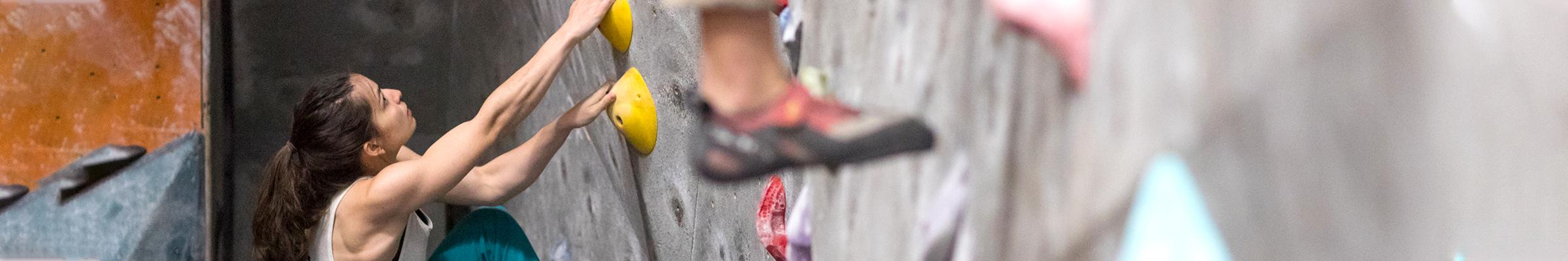 A banner featuring a portrait of a girl training in rock climbing.